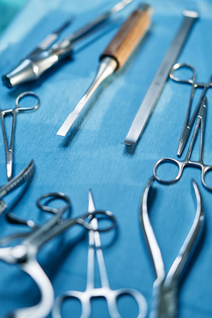 A detailed view of stainless steel dental and surgical instruments on a blue background.